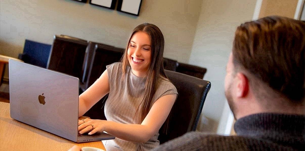 Katie, Aura's Lincolnshire mortgage adviser, smiling at a laptop while meeting a client