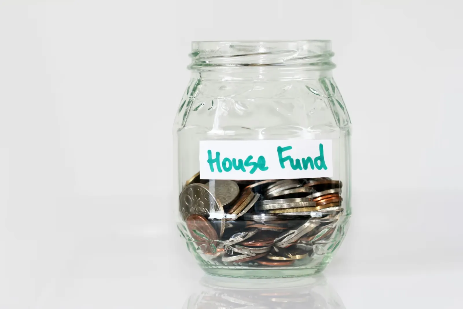 Glass jar of coins labelled House Fund